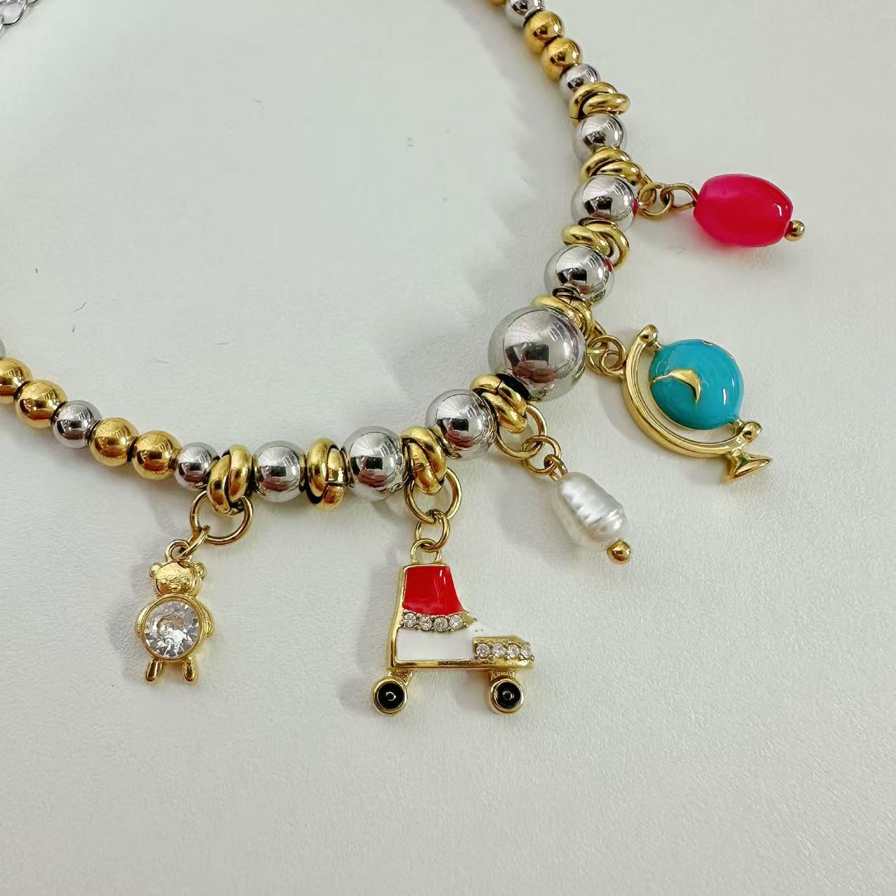 (B122)Bracciale bicolore in acciaio inox con tanti ciondoli