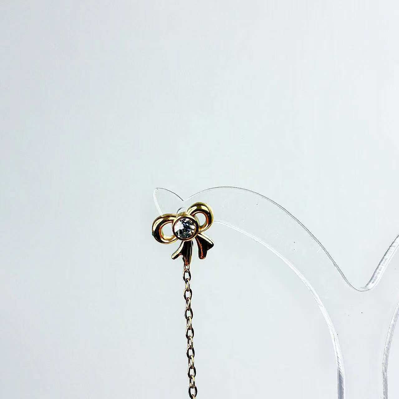 Orecchini “Fiocco Sussurrato” – Pendenti Sottili dal Gesto Elegante