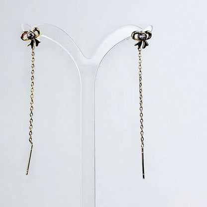 Orecchini “Fiocco Sussurrato” – Pendenti Sottili dal Gesto Elegante